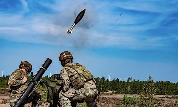A Finnish soldier fires a mortar under the supervision of U.S. soldiers assigned to the Army's 4th Squadron, 10th Cavalry Regiment, 3rd Armored Brigade, 4th Infantry Division during a cross weapons training at Niinisalo, Finland, July 21, 2022. (U.S. Army photo by Capt. Tobias Cukale)