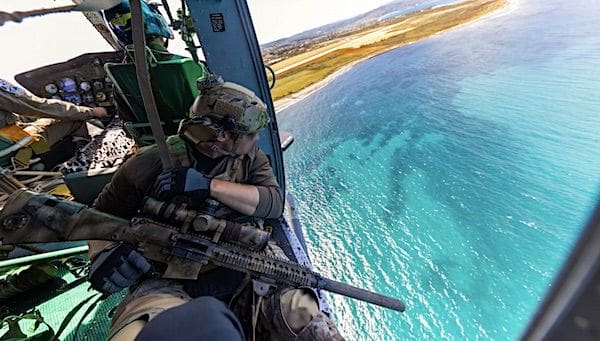 An Army Special Forces solider rides in a Greek helicopter during the NATO Maritime Interdiction Operational Training Centre Sniper Course in Souda Bay Greece, April 21, 2021. The course was designed to improve the accuracy of snipers from land, air and naval vessels. (U.S. Army photo by Sgt. Patrik Orcutt)
