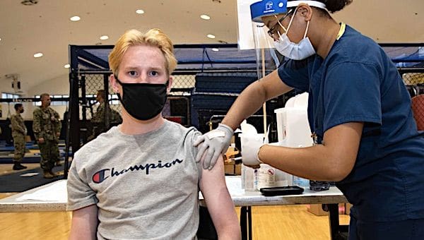 Judson Leary, a 16-year-old Kinnick High School student, receives his first dose of the Pfizer COVID-19 vaccine from Hospital Corpsman 1st Class Janasia Spotson during a vaccine distribution May 20, 2021, at Commander, Fleet Activities Yokosuka's Hawk's Nest in Japan. (U.S. Navy photo by Tetsuya Morita)