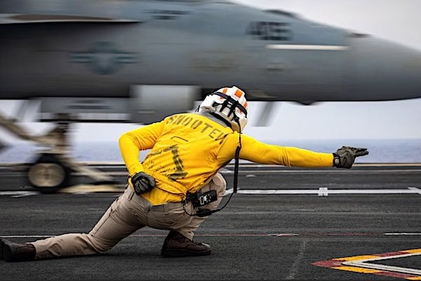 Navy Lt. Tom Sandford signals the launch of an F/A-18E Super Hornet on the flight deck of the USS Gerald R. Ford during a scheduled deployment in the U.S. 6th Fleet area of operations, Aug. 15, 2025. (U.S. Navy photo by Petty Officer 2nd Class Mariano Lopez)