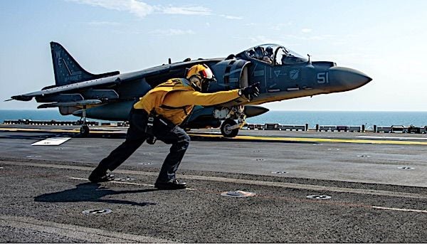 Aviation Boatswain's Mate (Handling) 1st Class Martre Gober signals to an AV-8B Harrier attached to Marine Attack Squadron 214 on the flight deck of the amphibious assault ship USS Essex in the Arabian Gulf, Sept. 19, 2021. (U.S. Navy photo by Mass Communication Specialist 3rd Class Isaak Martinez)
